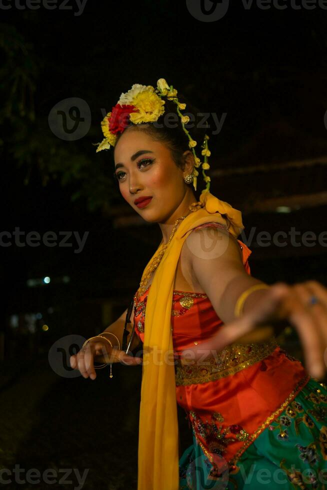 retrato do uma tradicional sundanês dançarino dançando com a laranja cachecol suspensão baixa dela corpo foto