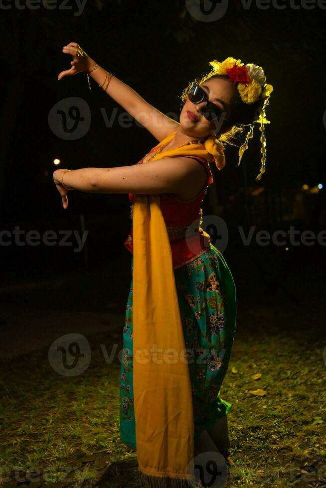 uma tradicional indonésio dançarino dançando com a corpo torção em etapa foto