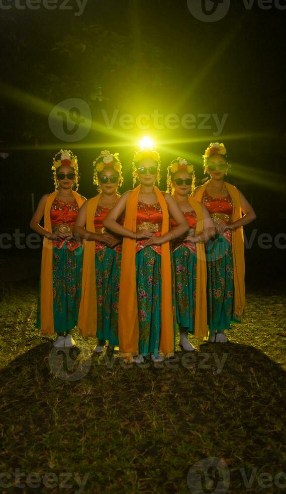 uma grupo do indonésio tradicional dançarinos dança com seus amigos dentro frente do a etapa luzes foto