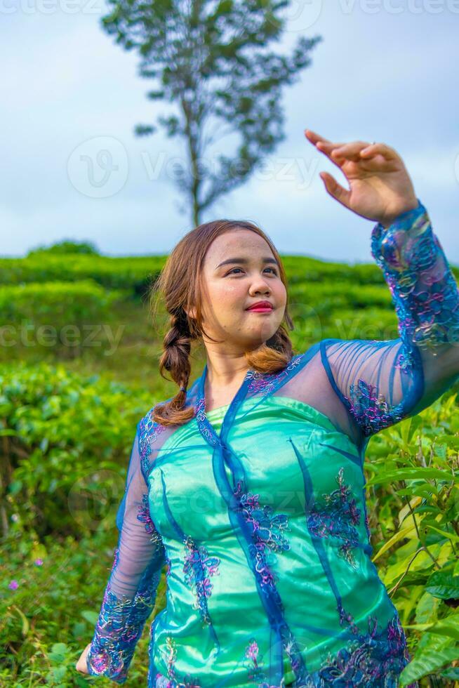 a ásia mulher dentro uma azul camponês vestir em pé entre a chá jardins foto