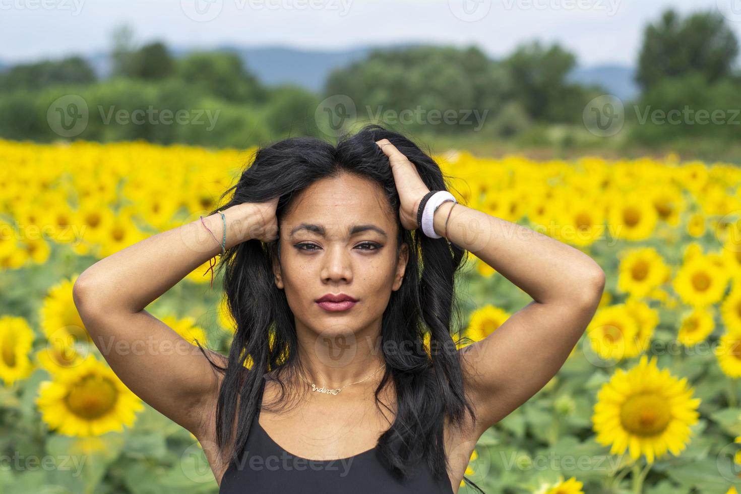 garota indiana cheirando uma flor de girassol foto