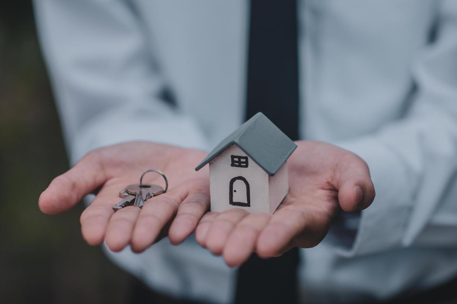 mão dando seguro de aluguel de venda de negócios de casa chave foto