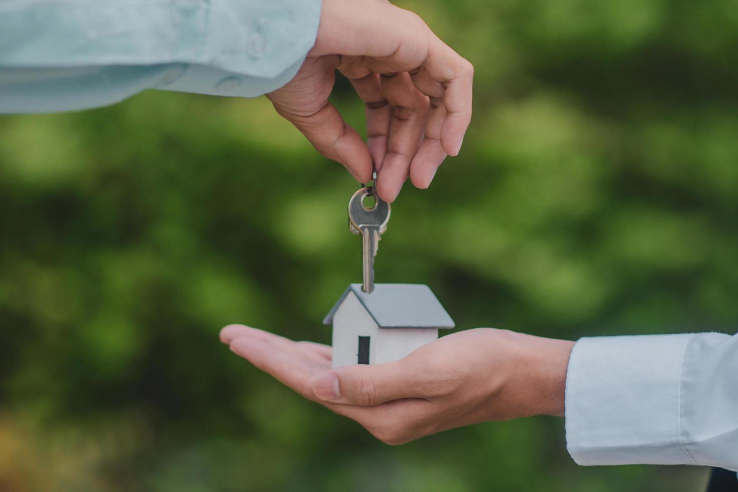 mão dando seguro de aluguel de venda de negócios de casa chave foto