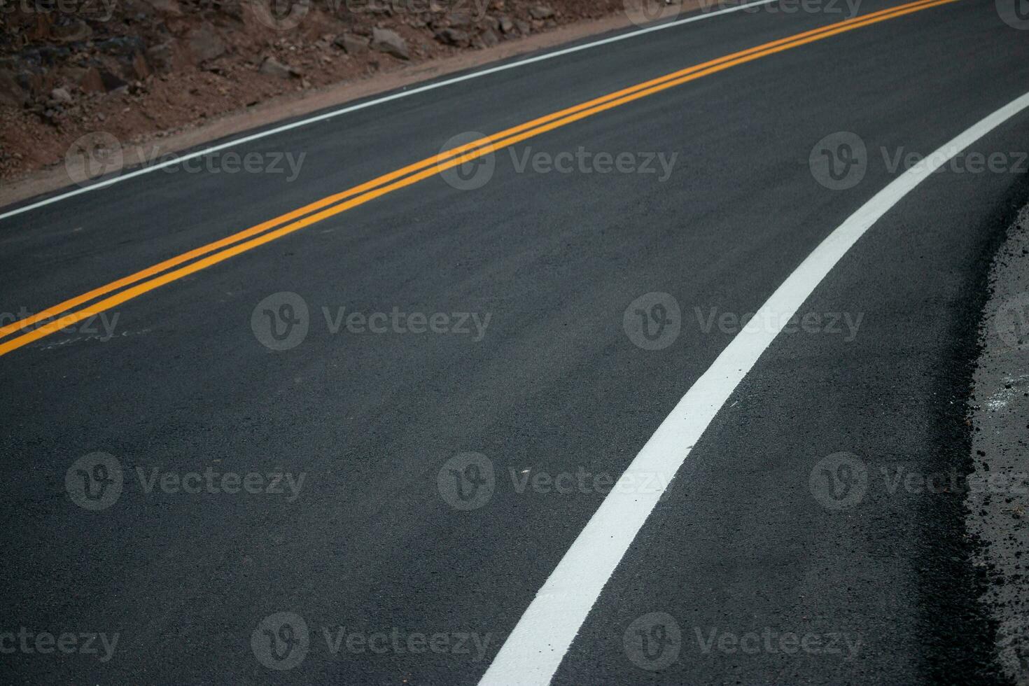 a asfalto estrada tem amarelo e branco tráfego linhas cruzando a montanhas. foto