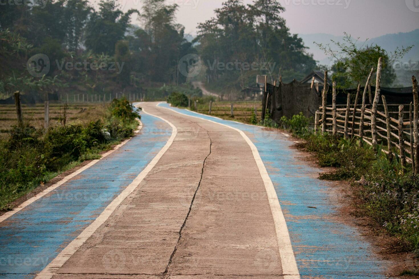 a concreto estrada dentro a campo tem azul caminhos para bicicletas dentro a vales. foto