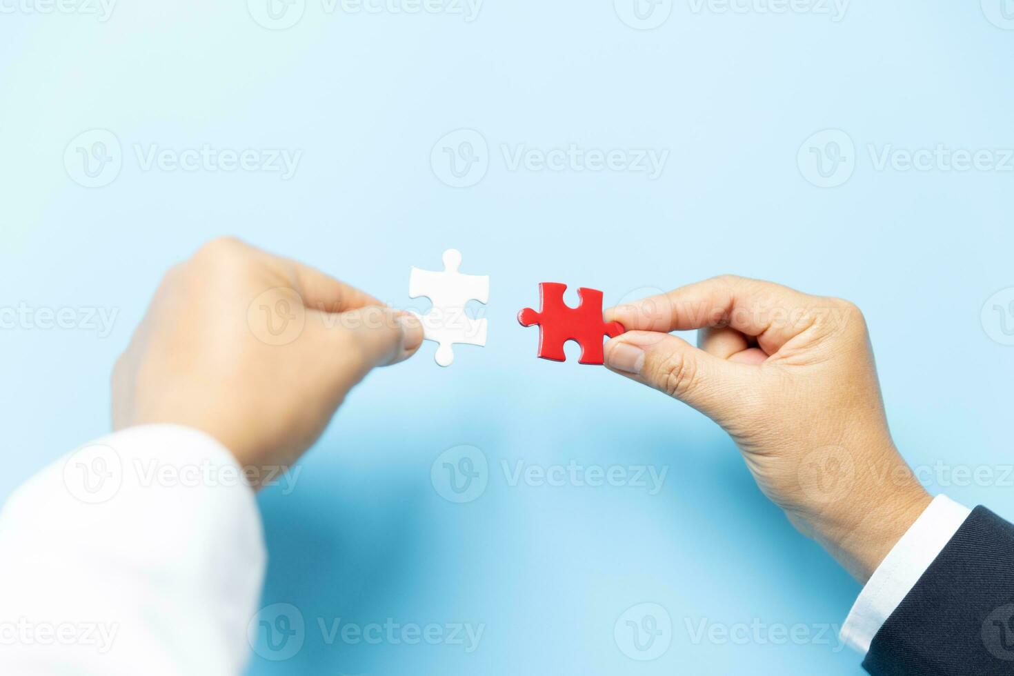 dois mãos tentando para conectar casal enigma peça em azul fundo. trabalho em equipe conceito. fechar-se mão do conectando quebra-cabeças quebra-cabeça. foto