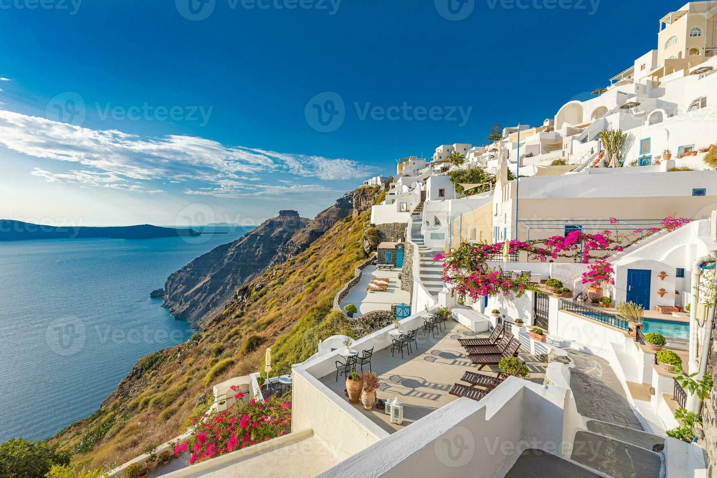 surpreendente tranquilo panorama do santorini caldeira e mar visualizar, relaxante flores, chaise salão com branco arquitetura. fantástico verão cênico Como férias, viagem feriado conceito bandeira. luxo vibrações foto