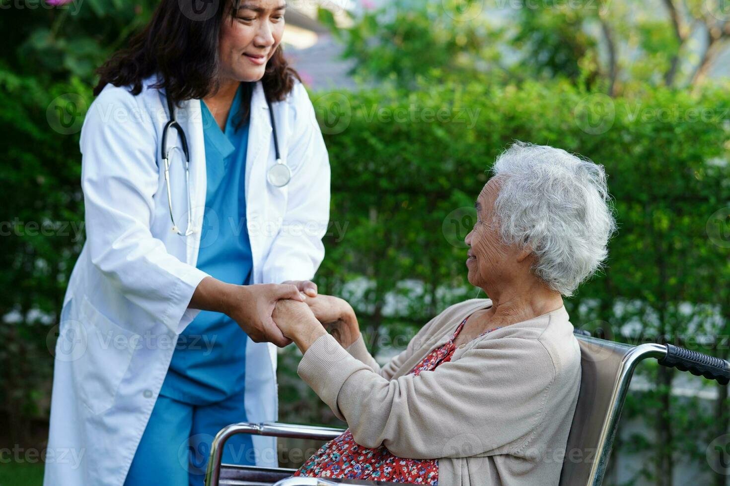 médico ajuda paciente idosa asiática com deficiência sentada na cadeira de rodas no parque, conceito médico. foto