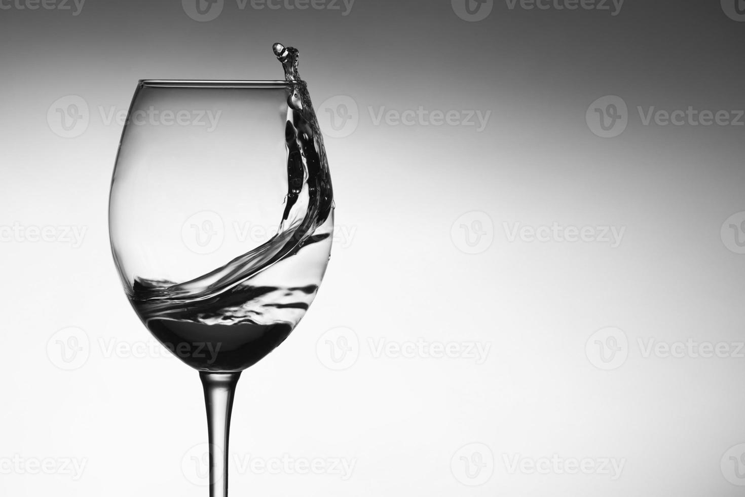 um jato de água em uma taça de vinho foto