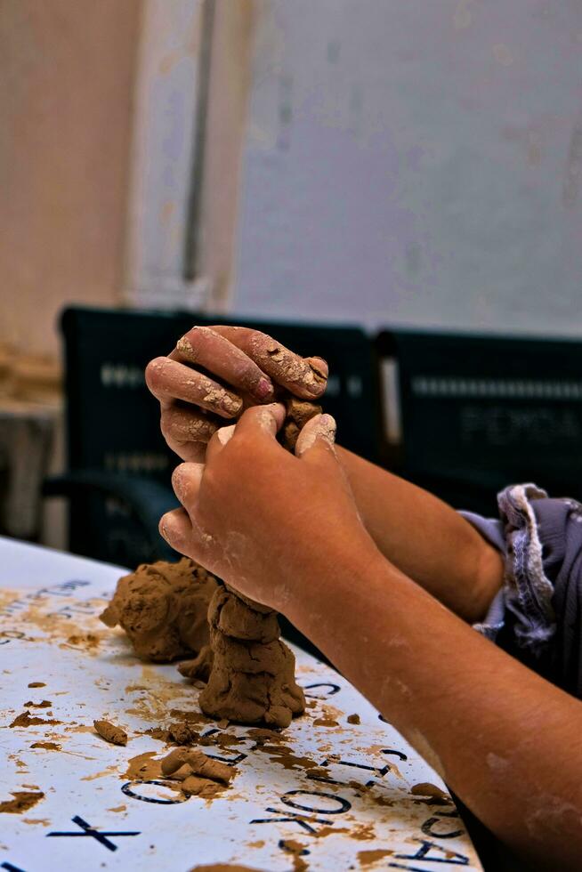 a mãos do uma criança quem é fazendo Atividades para faço artesanato a partir de argila ou frequentemente chamado uma cerâmica classe e alguns do a resultados foto