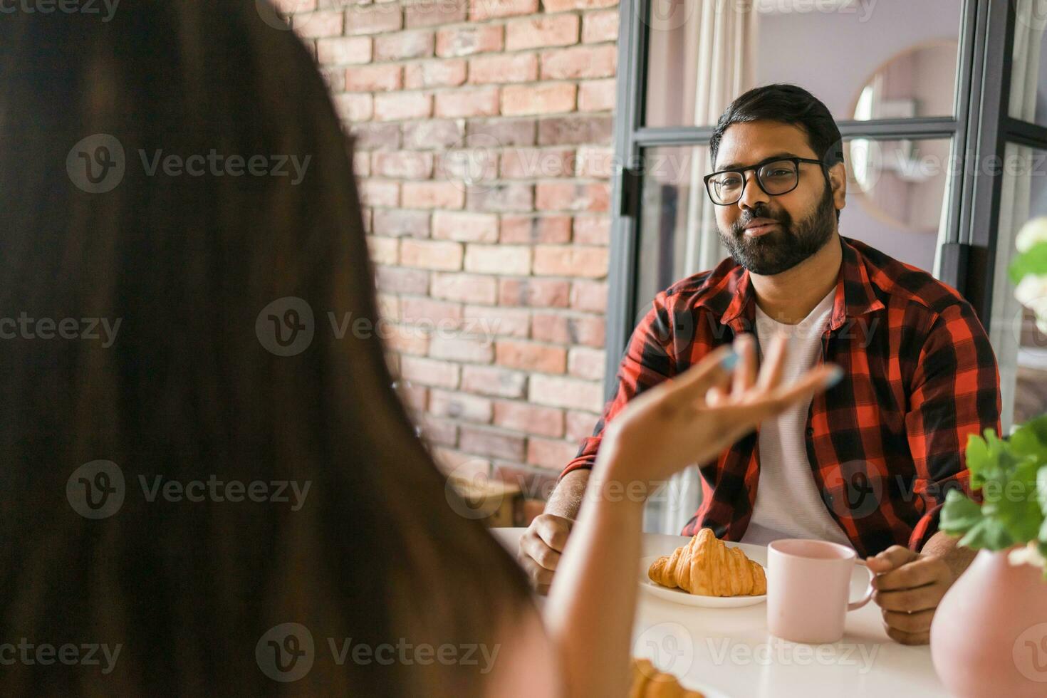 feliz indiano casal tendo café da manhã e pequeno conversa juntos dentro a cozinha - amizade, namoro e família foto