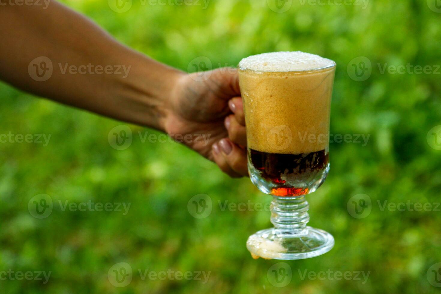 mulher mão detém uma cheio vidro do espumoso kvass, suave bebidas foto