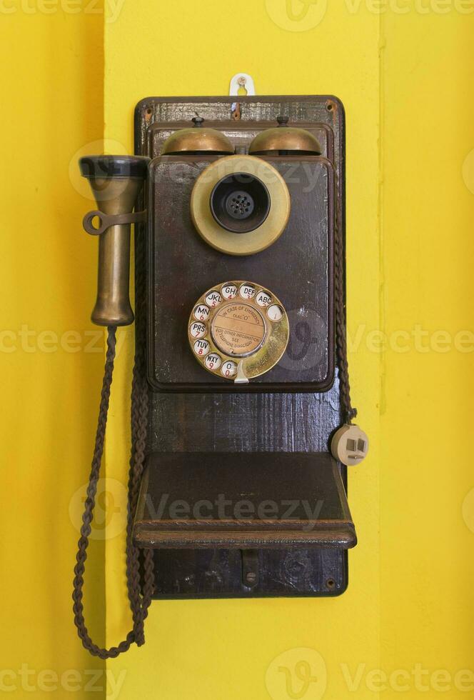 Antiguidade vintage Telefone amarelo grunge fundo. foto