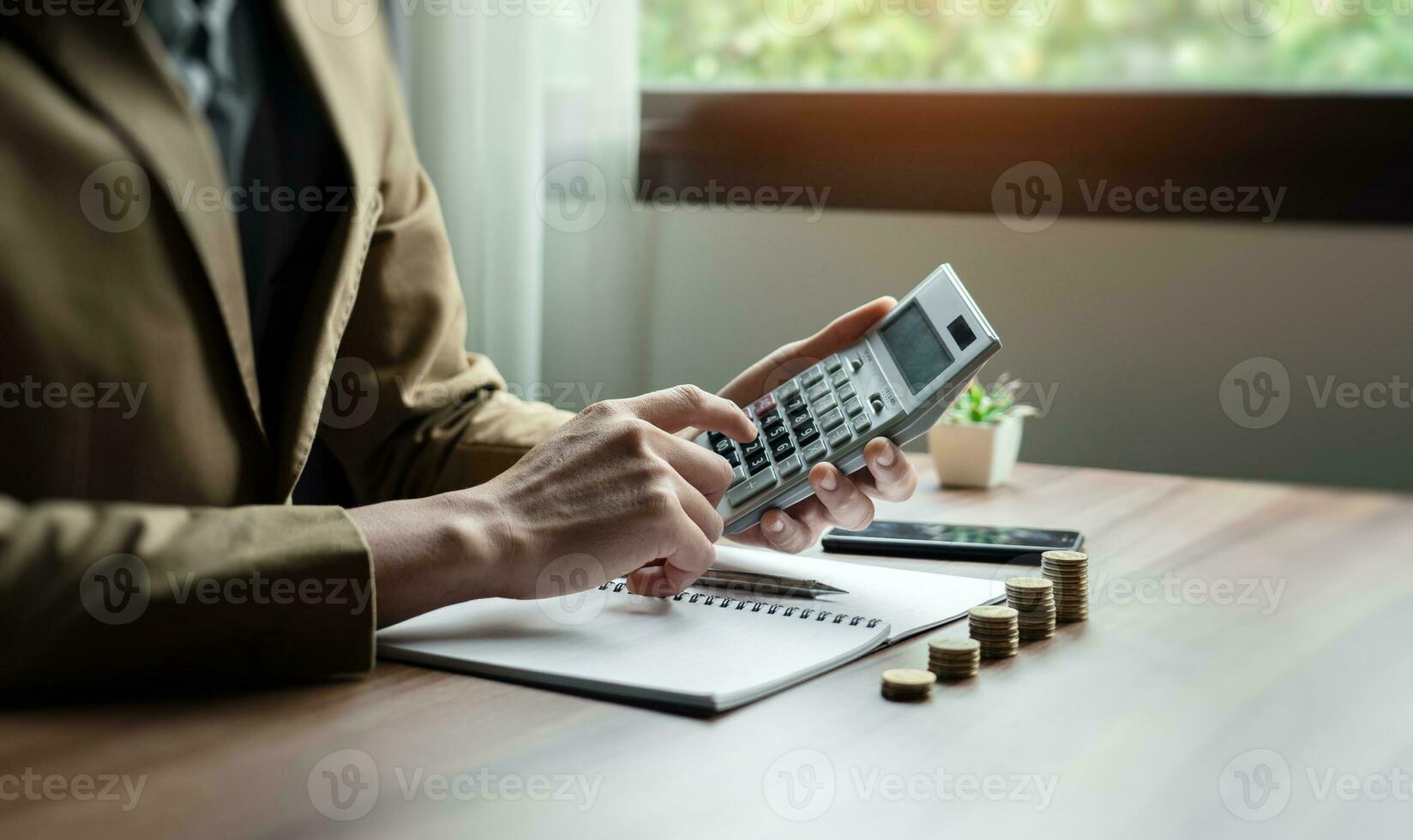 homem de negocios ou contador mão usando calculadora, calcular finança relatório dentro escritório, isto Auxilia financeiro planejamento e salvando para Construir riqueza para a futuro, grandes prazo Retorna em investimento foto