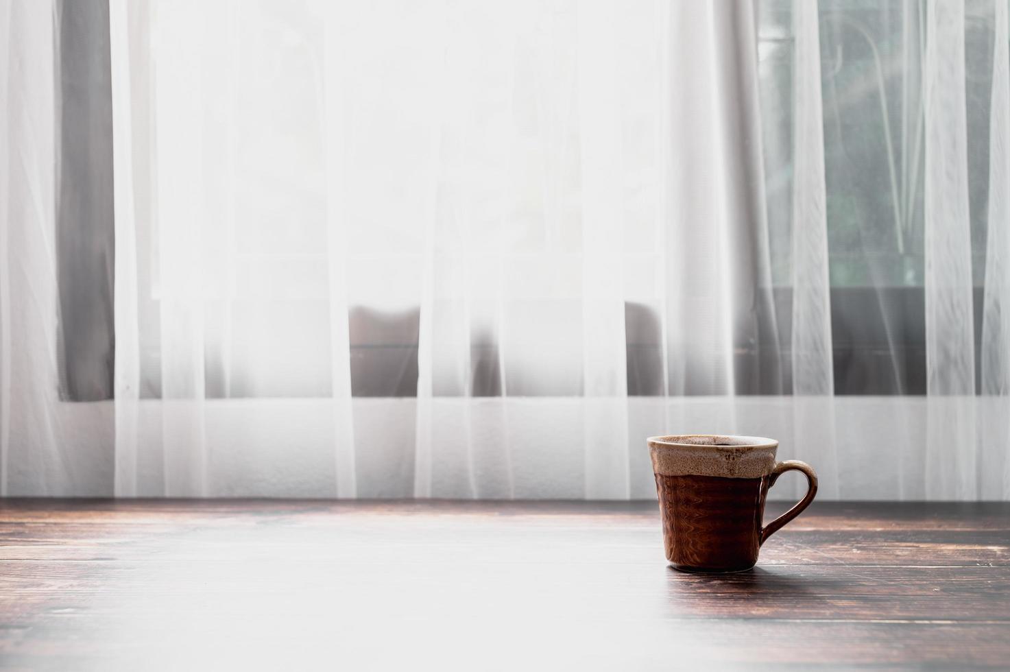 um copo de água e uma caneca de café estão na mesa. foto