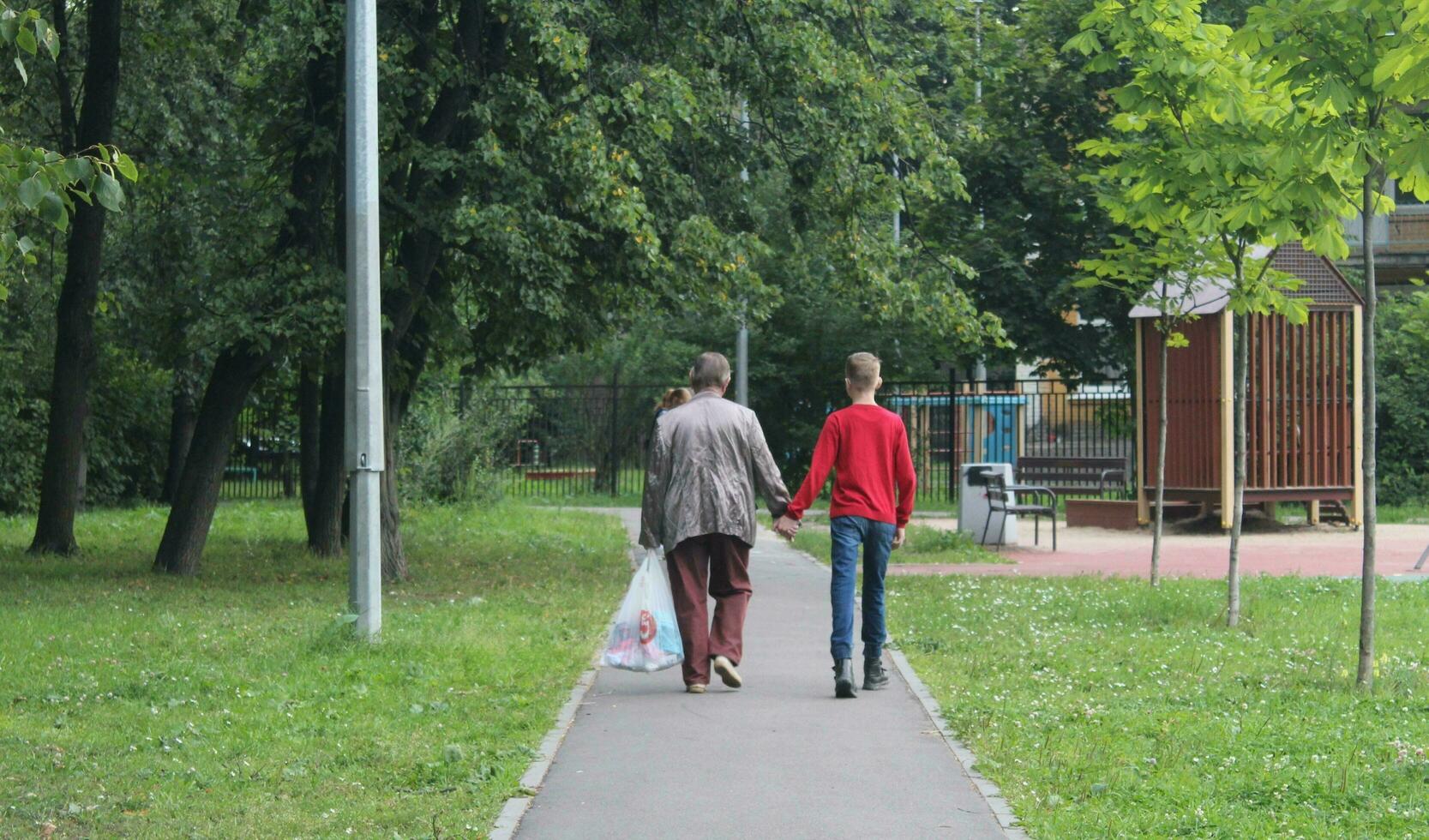 afundou Petersburgo Rússia - 08 07 2023 família férias, fim de semana. feliz pais e crianças caminhando dentro a parque. a feliz família anda em com uma criança em uma quieto rua dentro a verão. foto