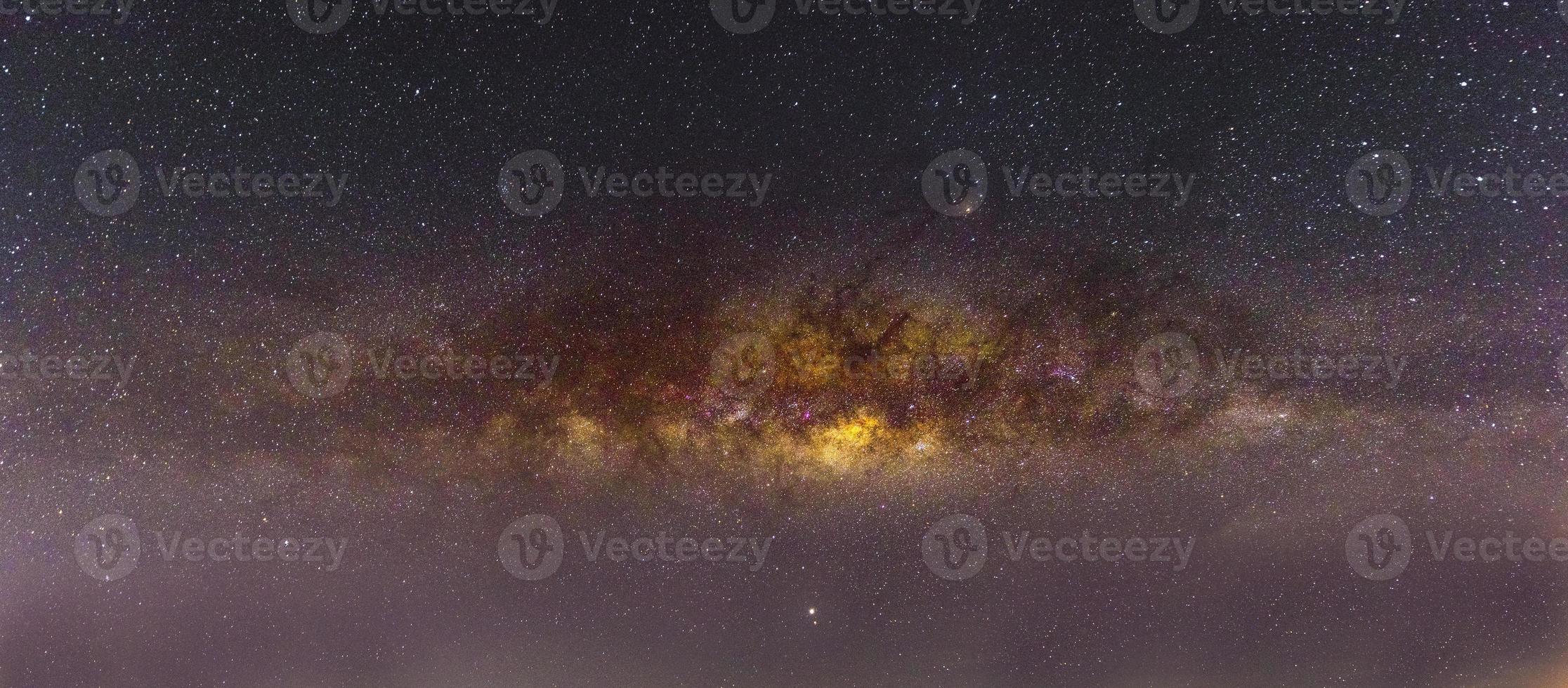 Cenário noturno com a Via Láctea colorida e amarela clara cheia de estrelas no céu no verão belo universo de fundo do espaço foto
