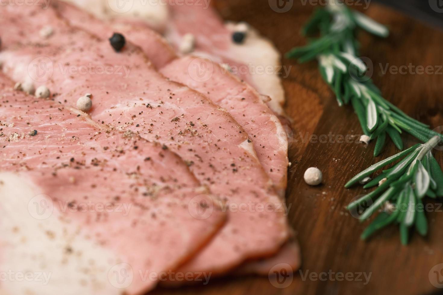 tiras de bacon cru alimentadas na tábua de cortar. foto