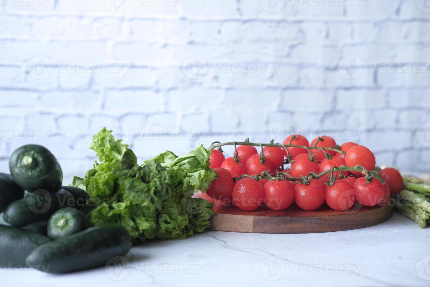 pimenta jalapeño, aspargos, tomate cereja, alface na tábua de cortar foto