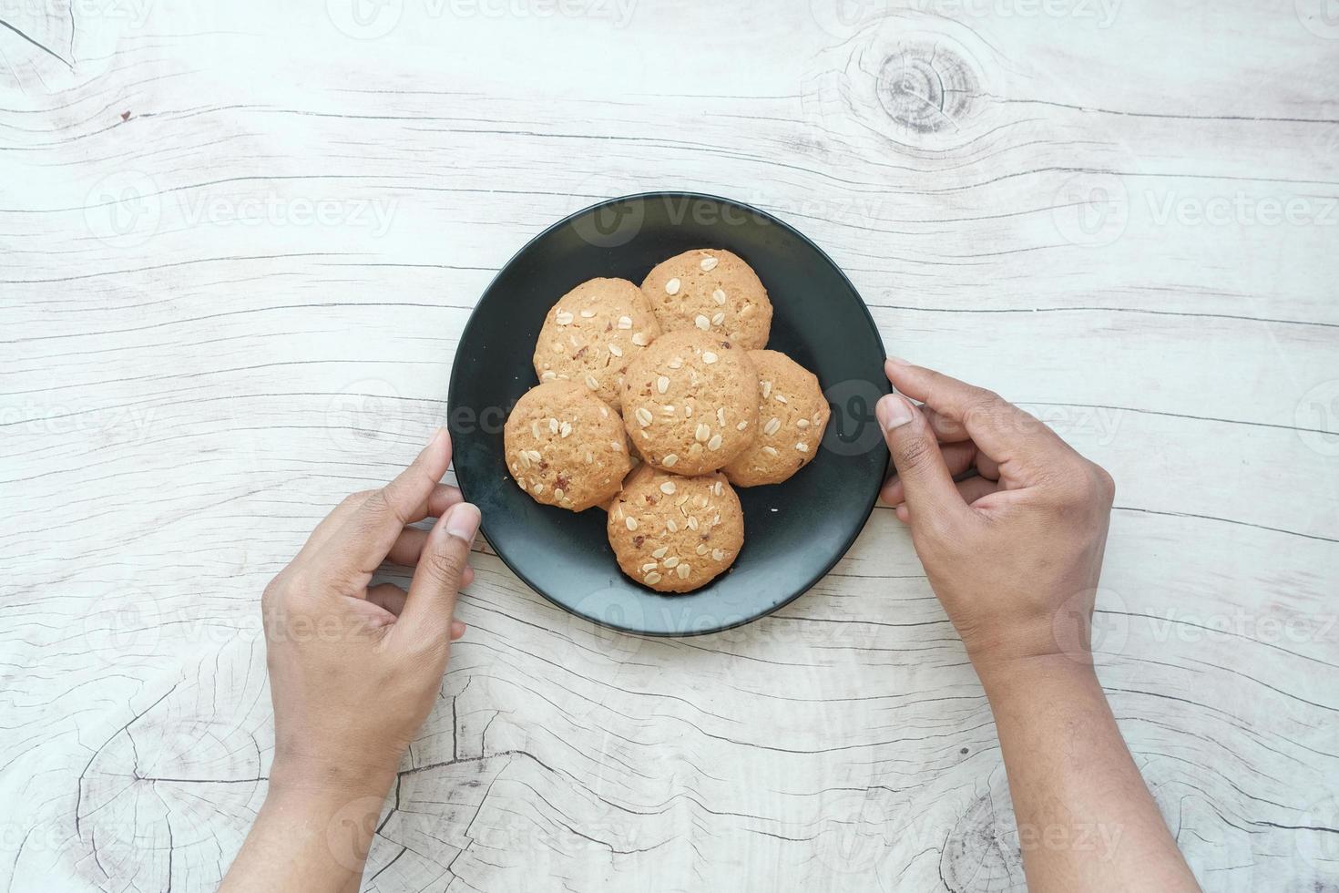 pegar biscoitos de refeição completa em fundo de madeira à mão foto