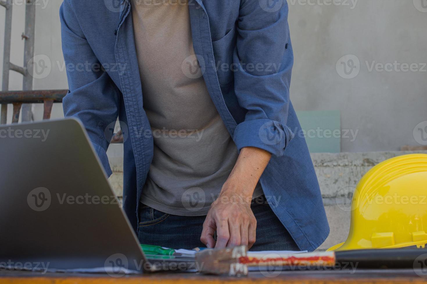 empregado trabalhador trabalhando por tecnologia de computador na construção do local foto