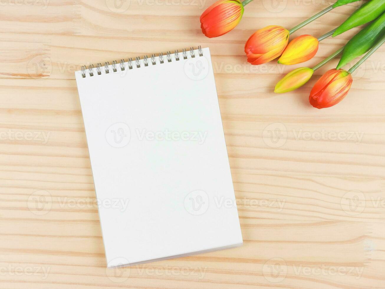 plano deitar do aberto em branco Páginas caderno ou diário com tulipas ramalhete em de madeira mesa fundo com cópia de espaço. foto