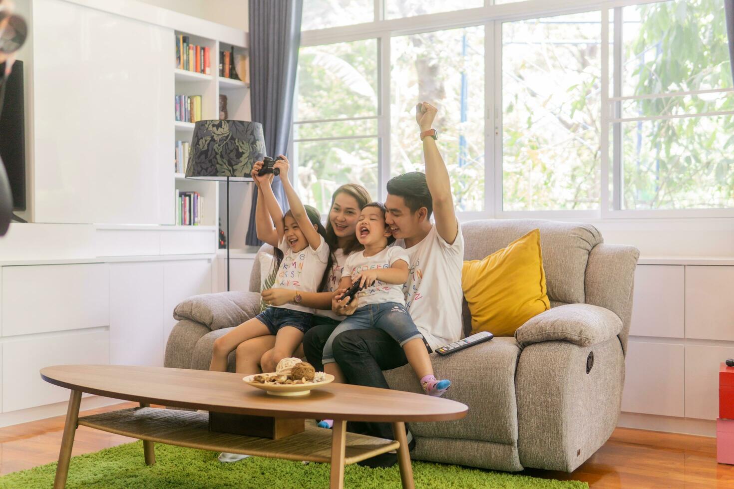 brincalhão família jogando vídeo jogos juntos dentro uma vivo sala. foto