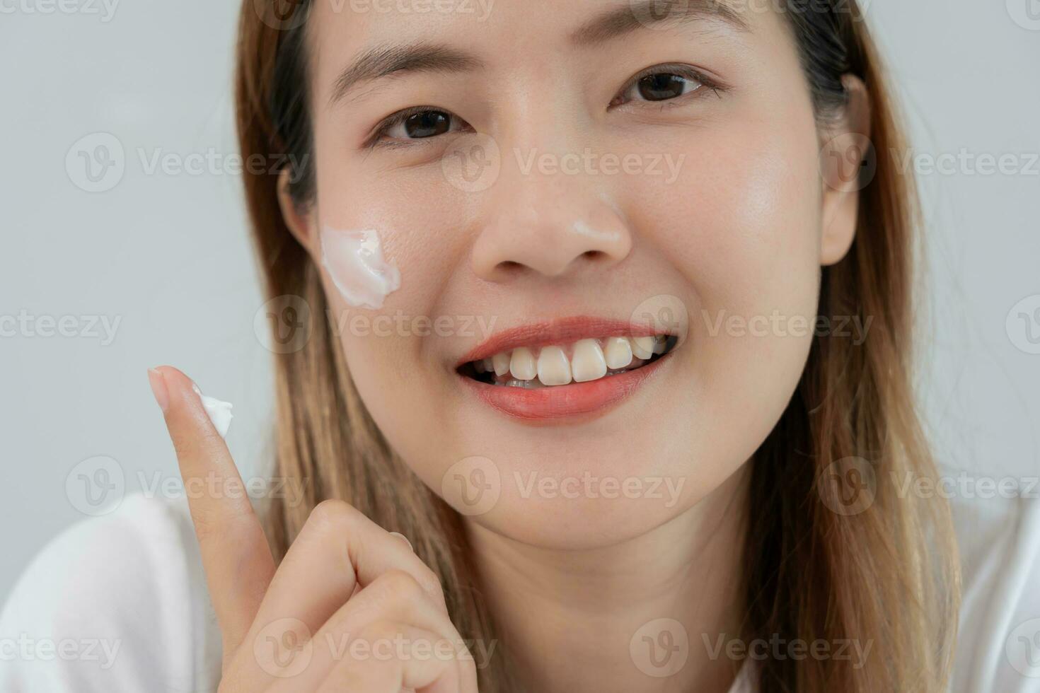 lindo ásia mulher sorrir usar creme para Boa pele. face do uma saudável mulher Aplique creme e inventar. propaganda para pele creme, anti-rugas, bebê face, branqueamento, hidratante, apertar poros sérum foto