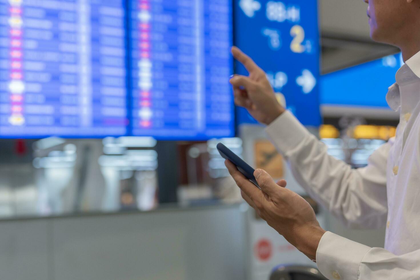 o negócio homem usando Móvel telefone para livro avião bilhete através conectados aplicativo, sentado em viagem verificação viagem Tempo em borda às aeroporto, viagem, pagamento, devido, reserva, on-line, Verifica dentro foto