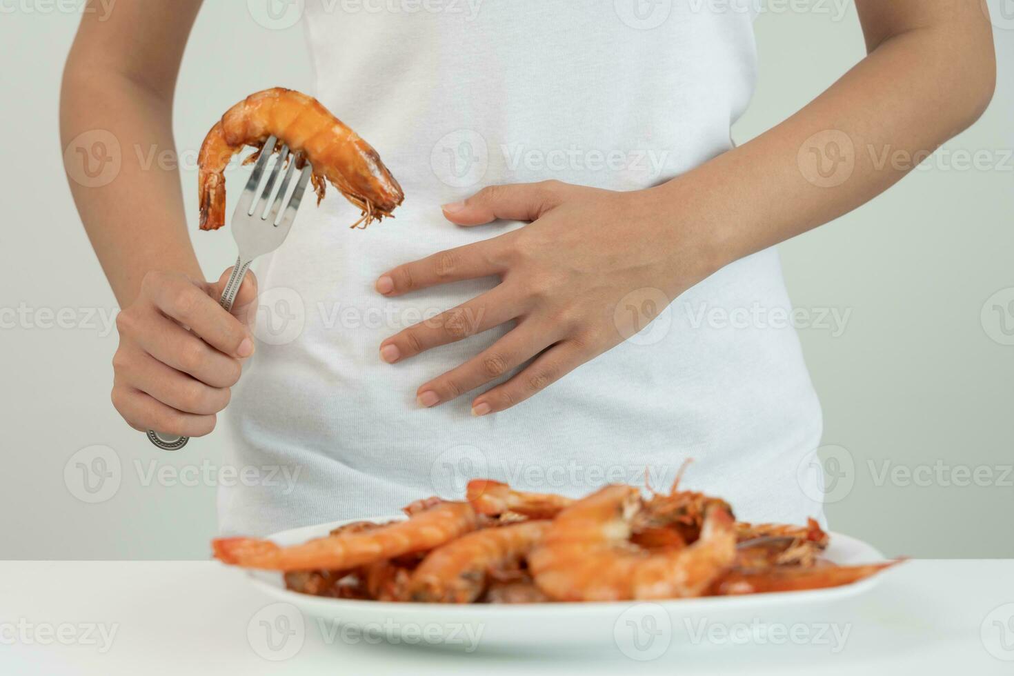 Comida alergias, mulheres ter reações comichão e vermelhidão depois de comendo camarão, frutos do mar alergia, coceira, irritação na pele, abdominal dor, diarréia, peito aperto, inconsciência, morte, forte evitar alergias foto