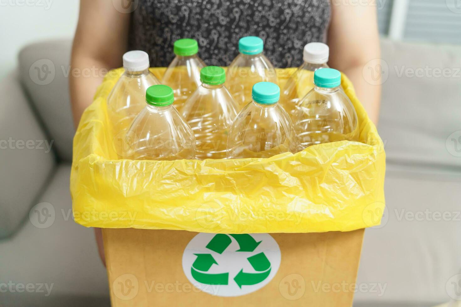 casa reciclar eco verde zero conceito mulher jogando esvaziar plástico garrafa dentro reciclando bin com amarelo lixo bolsas às lar. foto