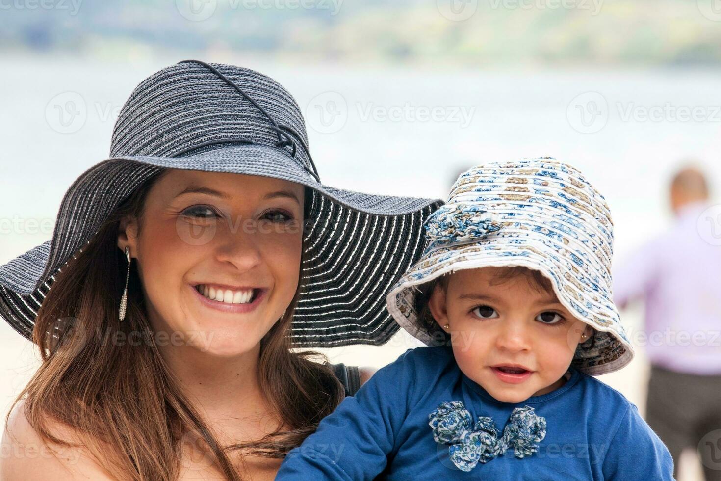 retrato do uma jovem mulher com dela bebê às a lindo branco de praia do lago total localizado dentro a departamento do boyaca às 3.015 metros acima mar nível dentro Colômbia foto