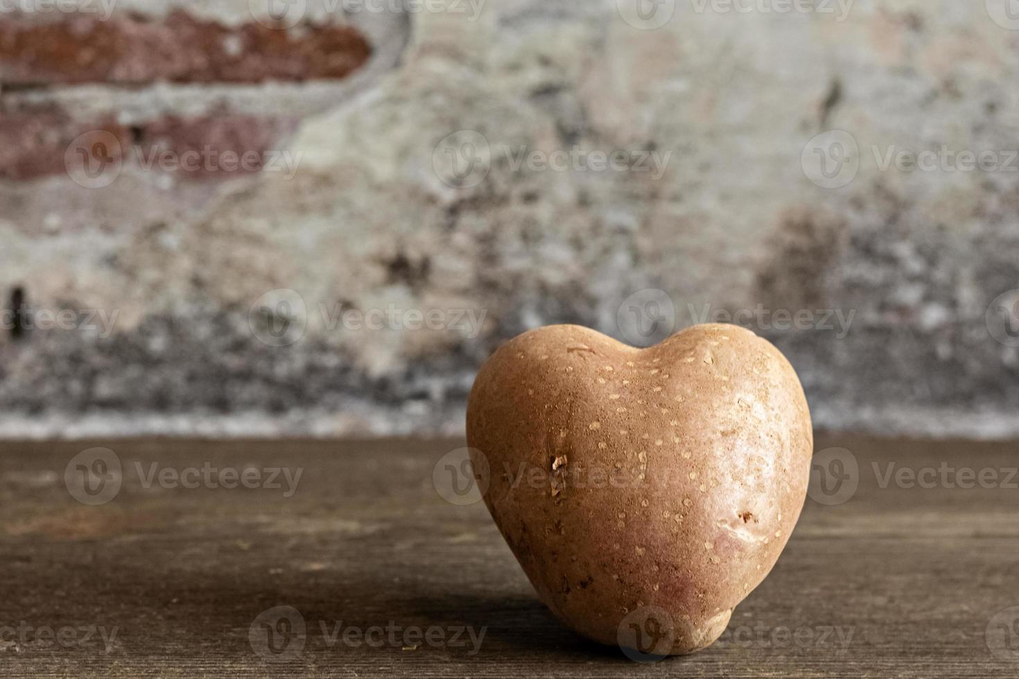 Batata vermelha em forma de coração em fundo vintage foto