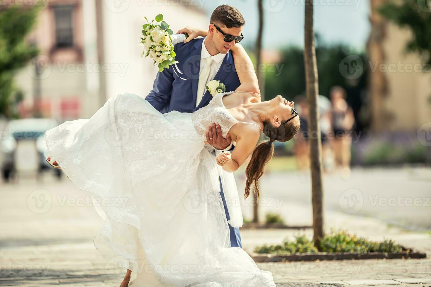 jovem homem segurando dela noiva gostar elas estavam dançando. elas vestem Casamento vestes e noiva detém uma adorável ramalhete fez do adorável flores foto