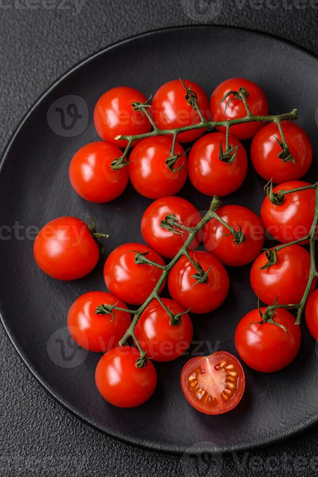 delicioso fresco cereja tomates em a galhos Como a ingrediente para cozinhando uma vegetariano prato foto