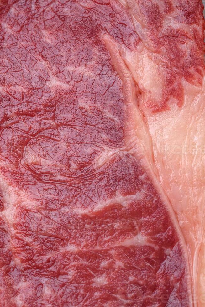 fresco cru carne striploin bife com sal, especiarias e ervas foto