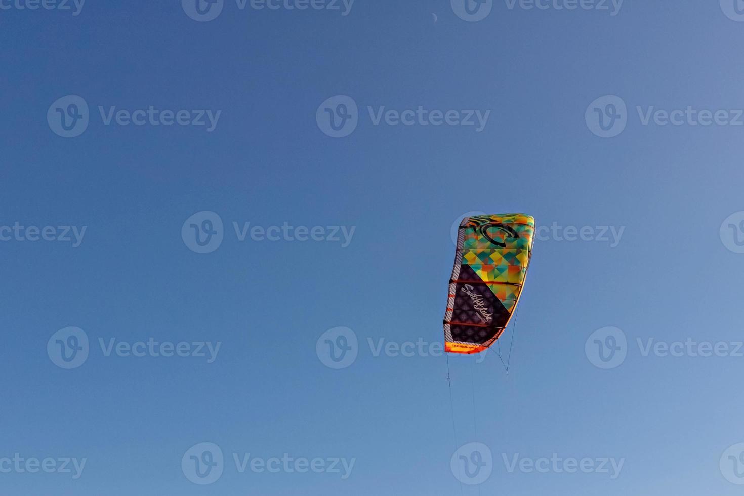 pára-quedas de cores brilhantes de kitesurf no céu azul foto