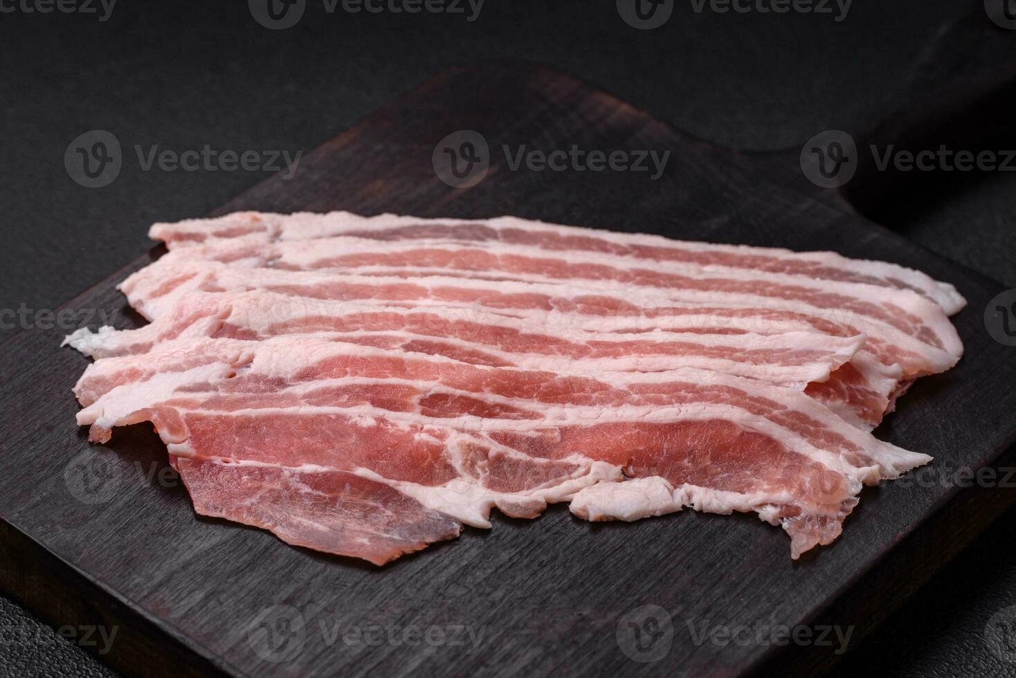 fresco cru bacon cortar para dentro fatias com sal, especiarias e ervas foto