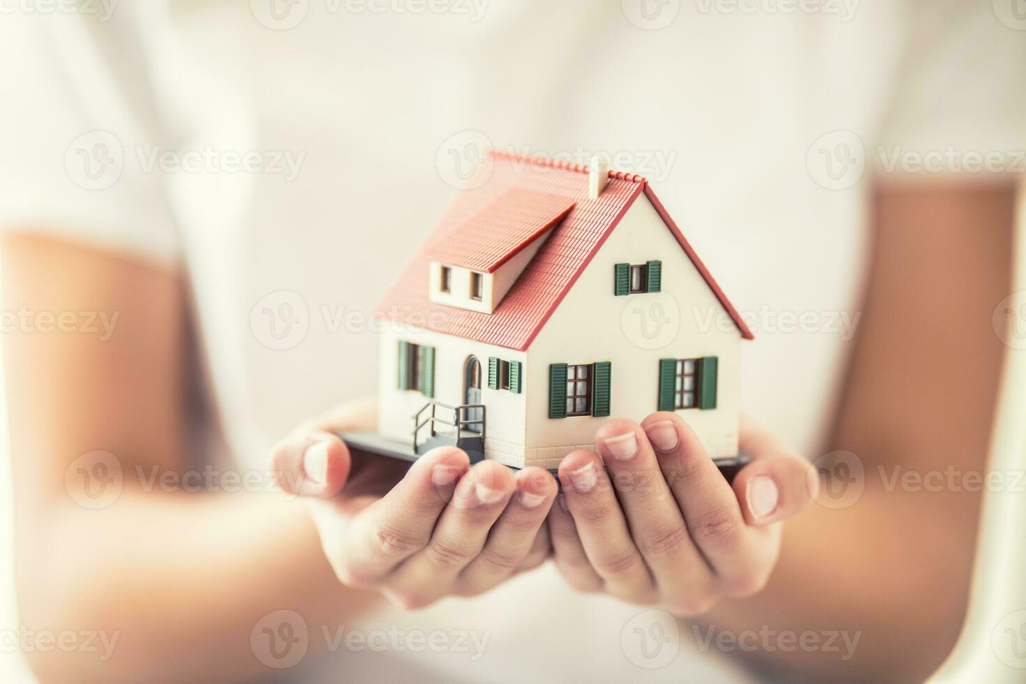 mãos do jovem mulher segurando modelo casa foto