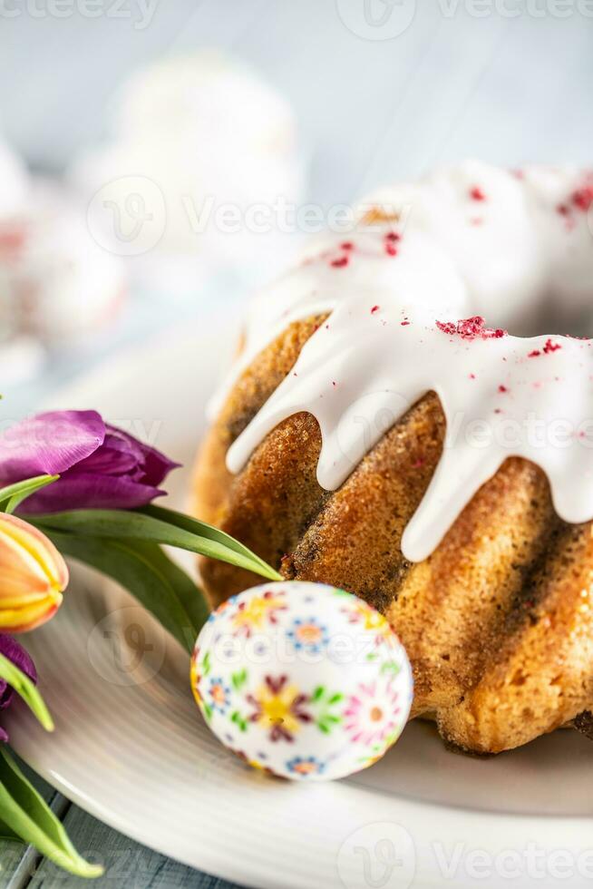 festivo Páscoa mármore bolo com gelo açúcar decorado à mão ovos e Primavera tulipas foto