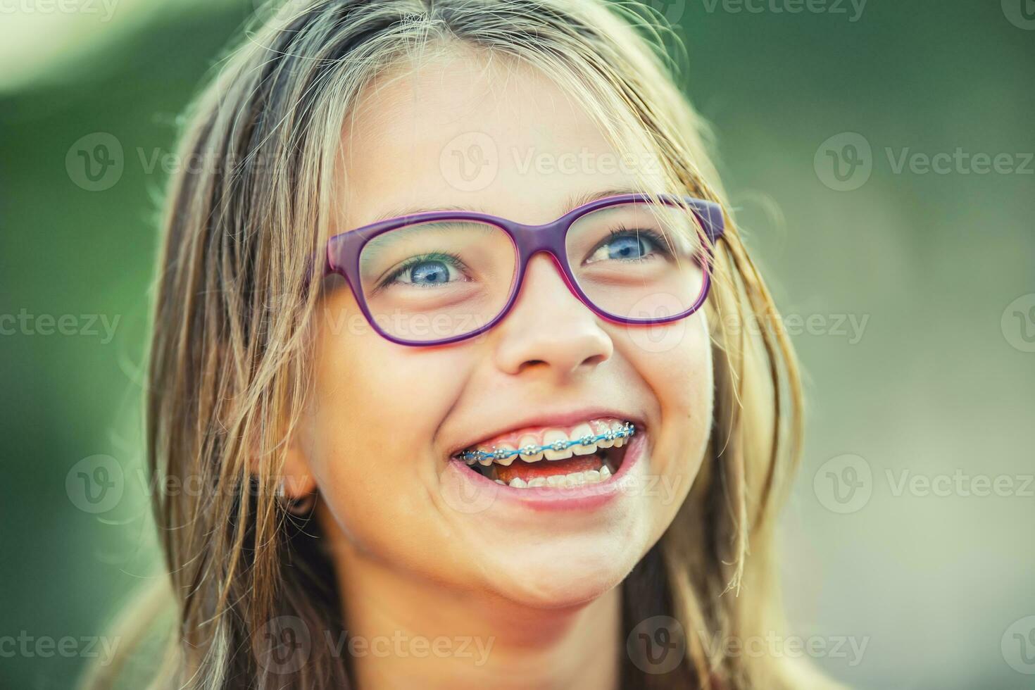 feliz sorridente menina com dental suspensórios e óculos. jovem fofa caucasiano loiro menina vestindo dentes suspensórios e óculos foto