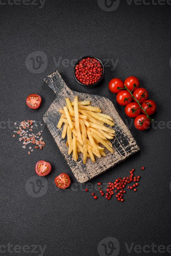 delicioso crocantes francês fritas com sal e especiarias em uma texturizado concreto fundo foto