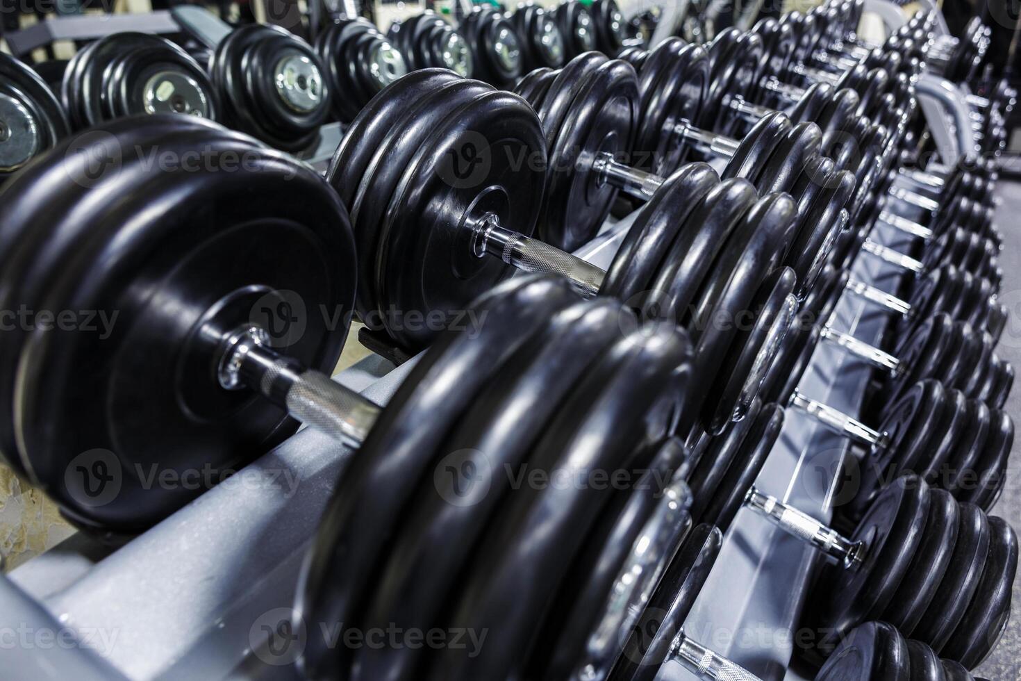 Preto haltere definir. fechar acima muitos emborrachado halteres em prateleira dentro esporte ginástica Centro , peso Treinamento equipamento conceito foto