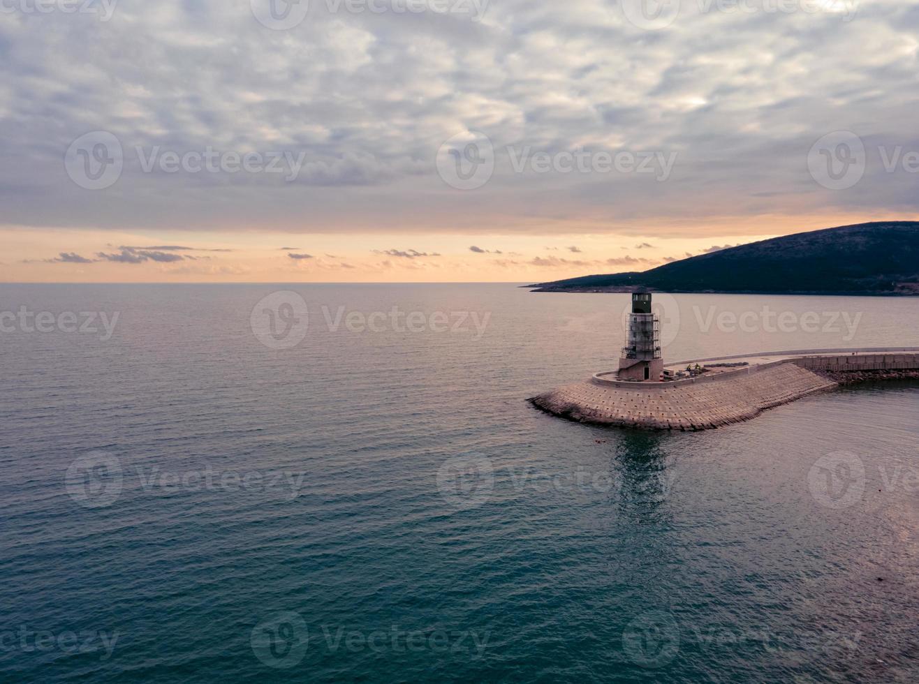 vista aérea do farol na baía de lustica em montenegro ao pôr do sol foto