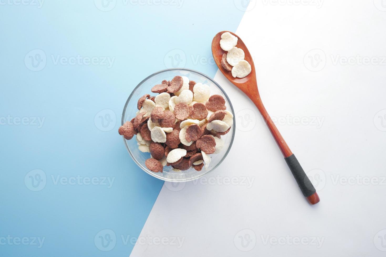 vista superior de flocos de milho de chocolate em uma tigela sobre fundo de dois tons foto