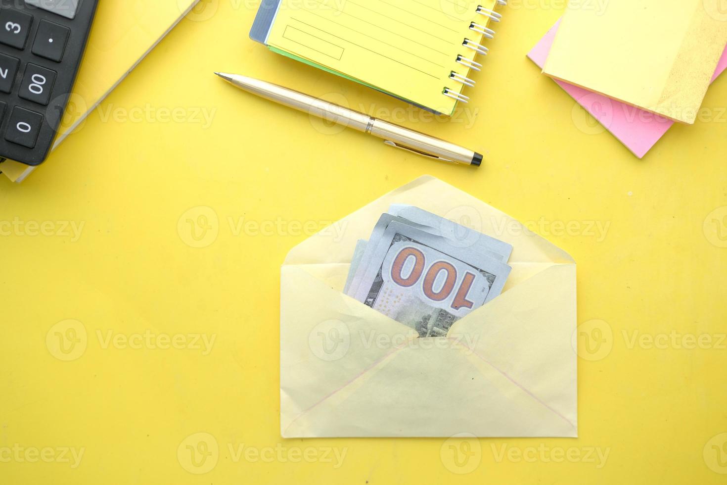 close-up de dinheiro em dólares americanos em um envelope sobre fundo amarelo foto