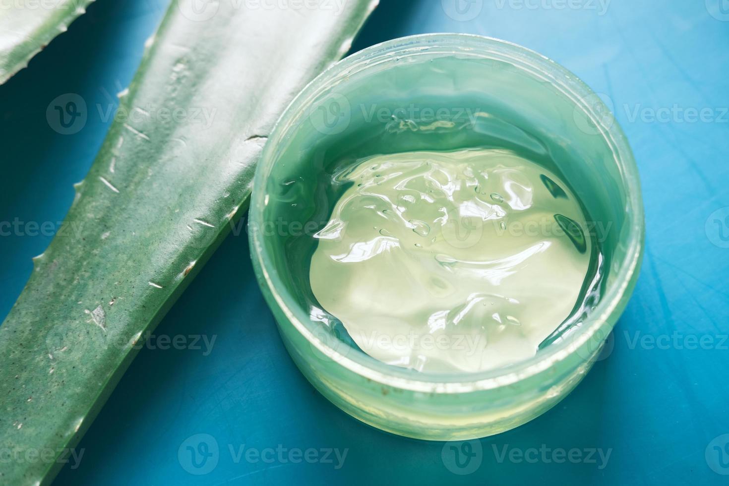 Aloe vera fresco fatiado e gel líquido em recipiente de plástico foto