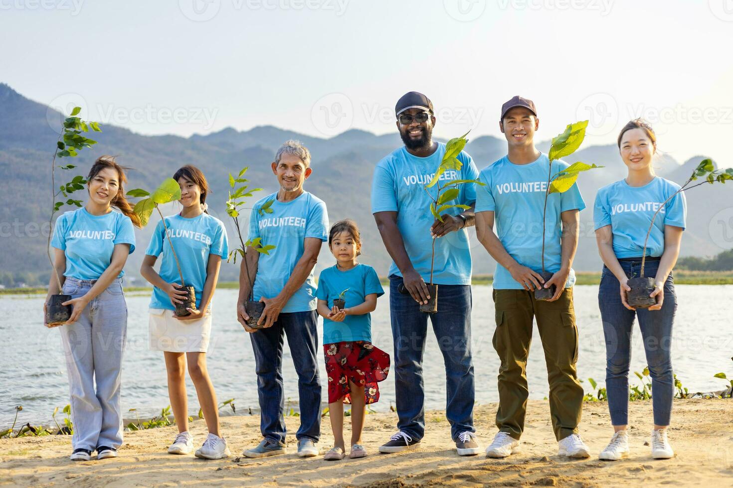 equipe do jovem e diversidade voluntário trabalhador grupo apreciar caridoso social trabalhos ao ar livre dentro árvore floresta plantio ngo trabalhos para brigando clima mudança e global aquecimento dentro litoral habitat projeto foto