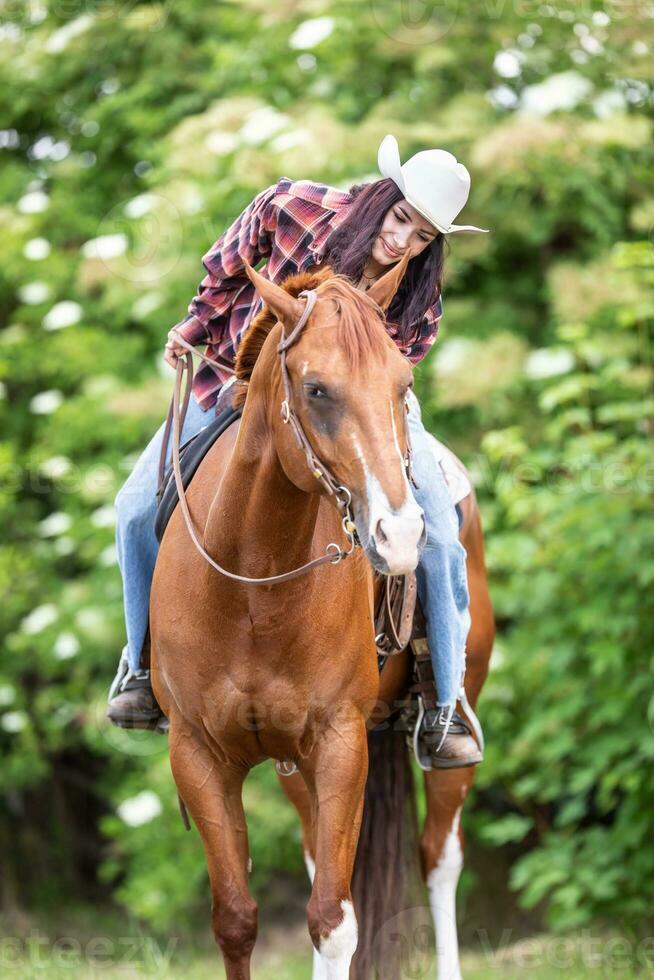 mulher equitação uma cavalo vestindo uma branco chapéu comunica com a animal foto