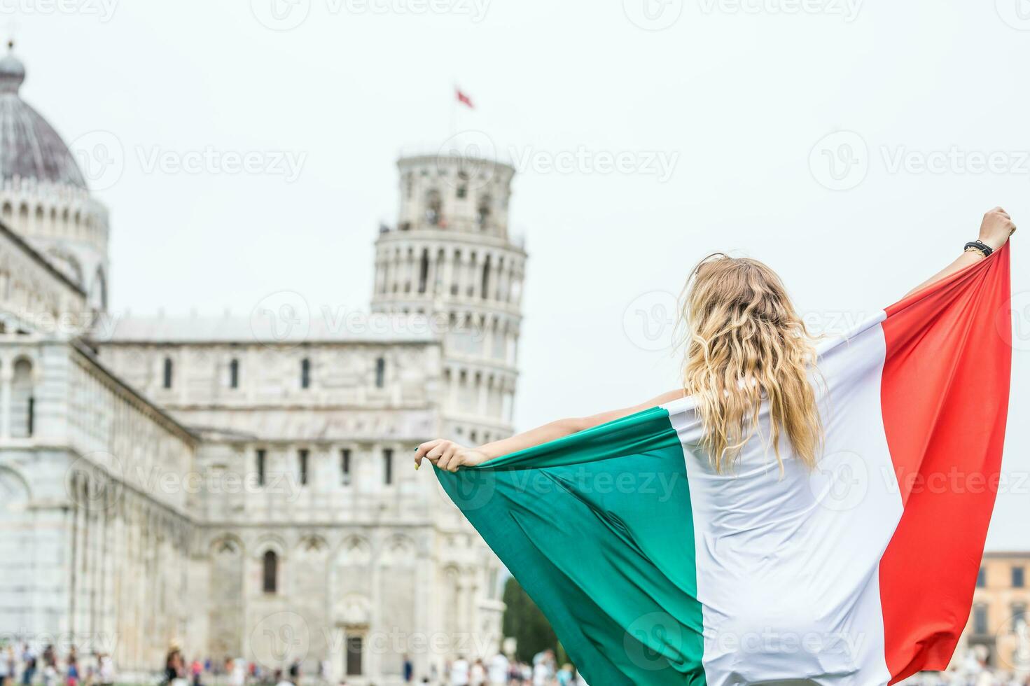 jovem adolescente menina viajante com italiano bandeira antes a histórico torre dentro Cidade pisa - Itália foto